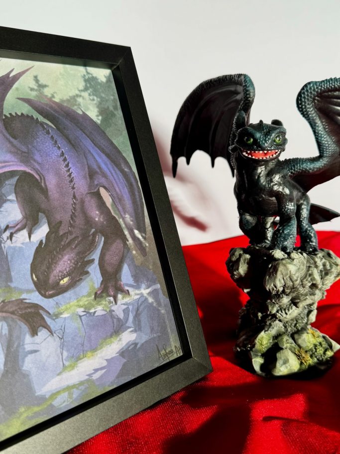 Estatua de dragón negro sobre una base, junto a un cuadro de un dragón volador.