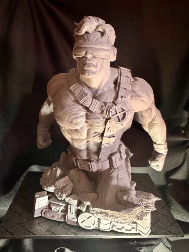 Escultura de un hombre musculoso con gafas y un cinturón militar, en pose de acción.