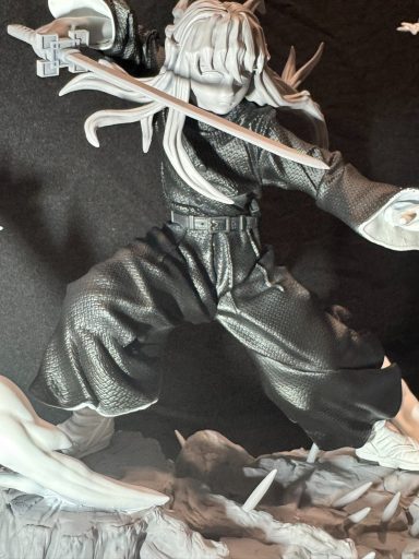 Figura de un guerrero en postura de combate, con cabello largo y espada.