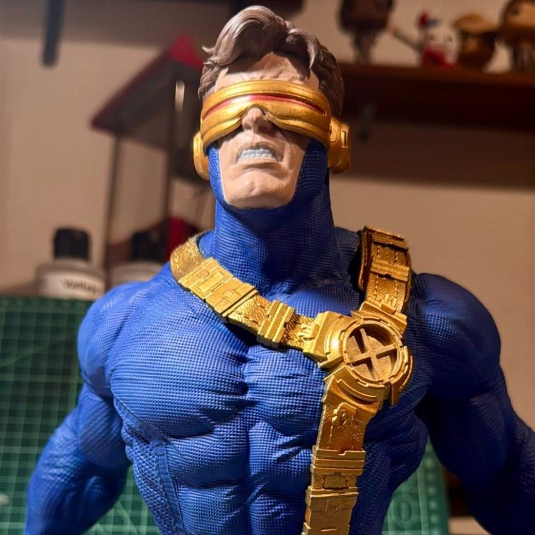 Figura de acción de un superhéroe muscular con gafas y traje azul y dorado. Ciclope X-MEN