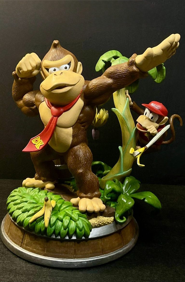 Estatuilla de Donkey Kong con gorra roja, sosteniendo su brazo y con Diddy Kong detrás.